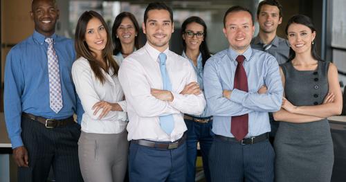 Exitoso grupo empresarial multiétnico en la oficina mirando a la cámara sonriendo