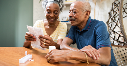 senior couple at kitchen table reviewing medicine label information